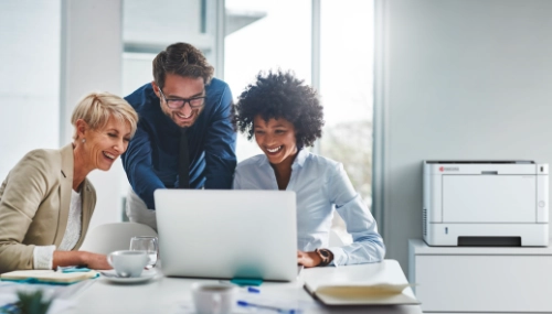 People surrounding a laptop with printer in the background